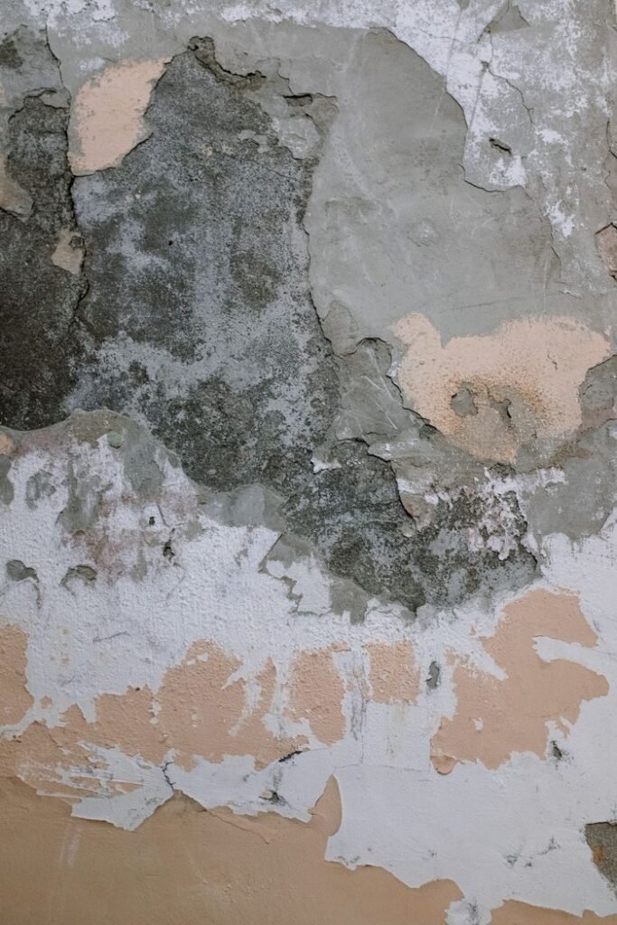 Close-up of an old wall with peeling paint and visible decay texture, perfect for backgrounds.